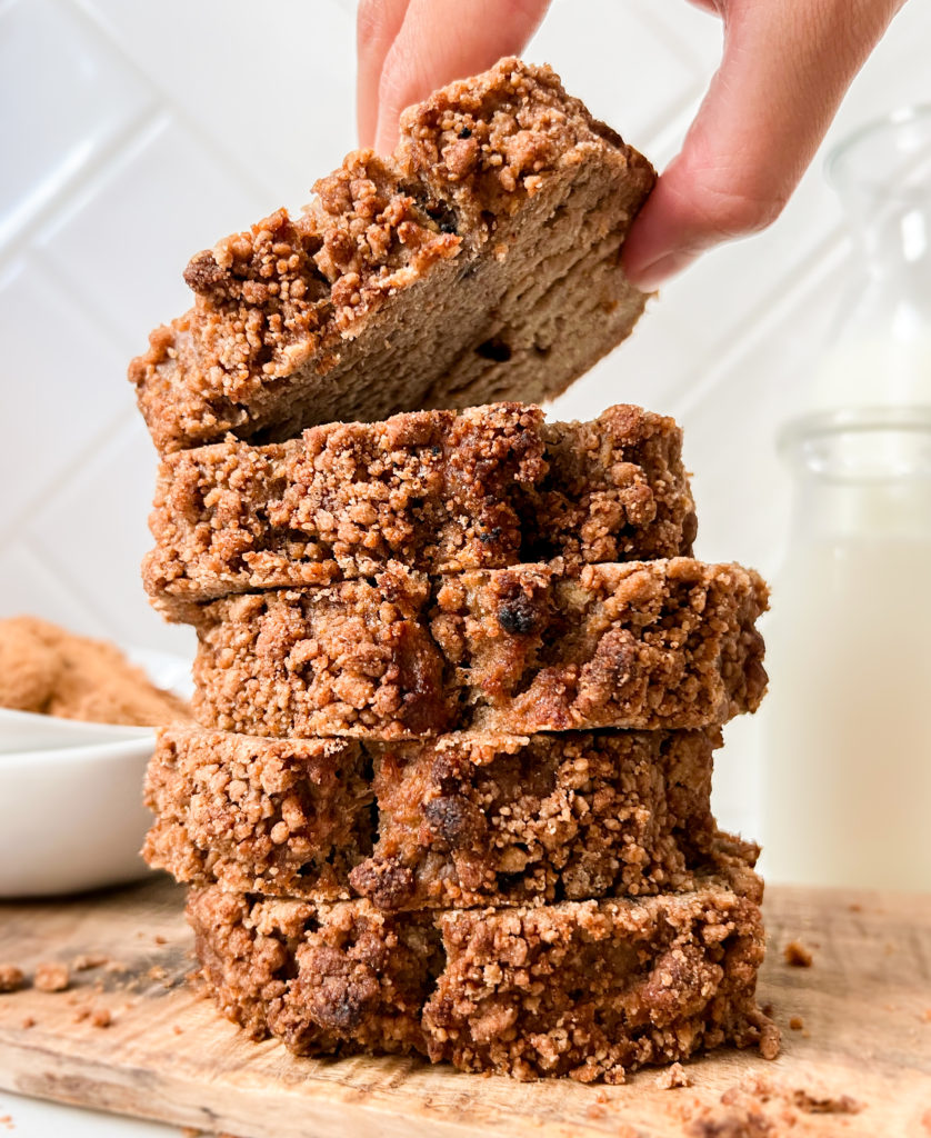 coffee cake slices stacked on a cutting board next to a bottle of milk