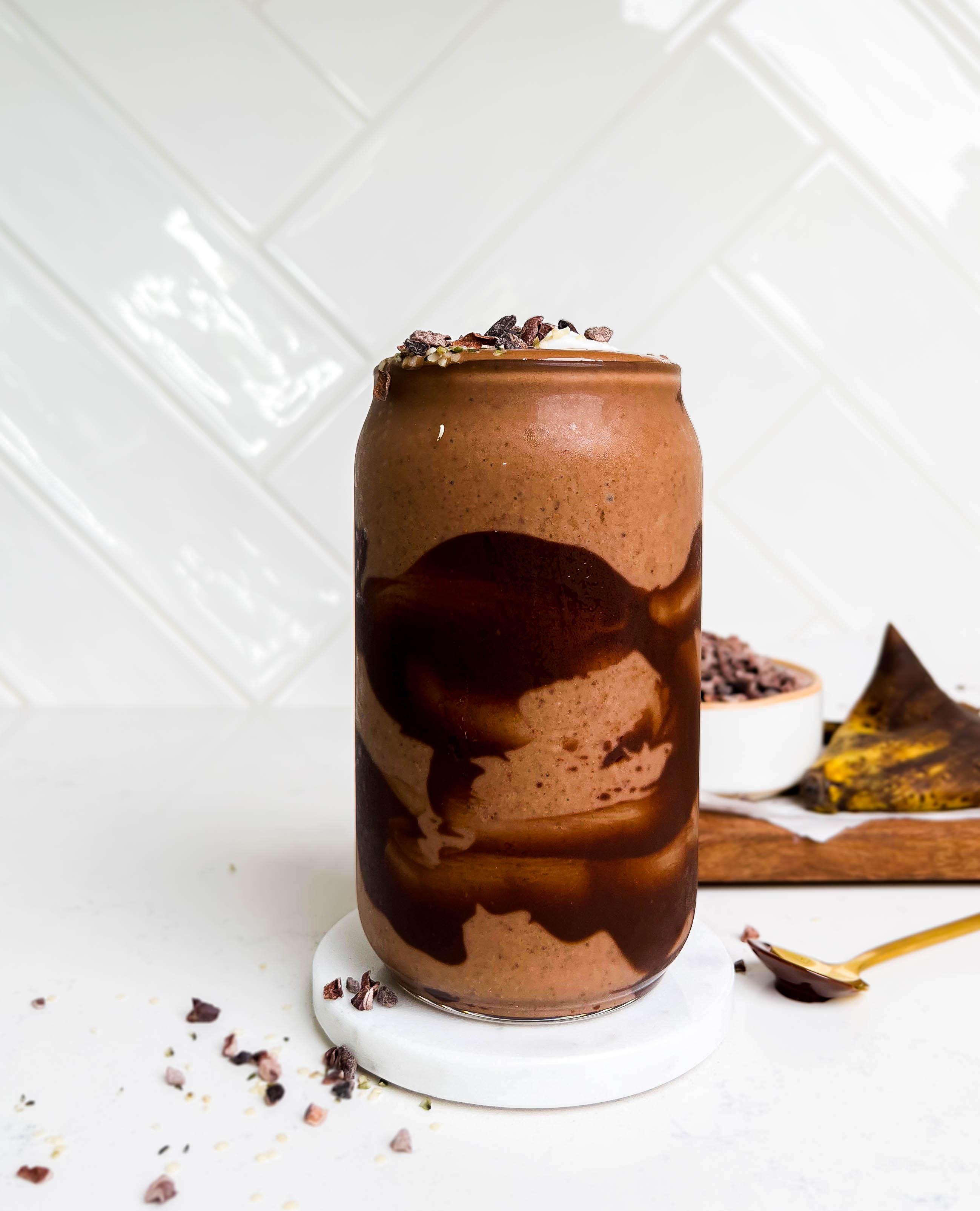 a glass of dark chocolate smoothie with chocolate swirls