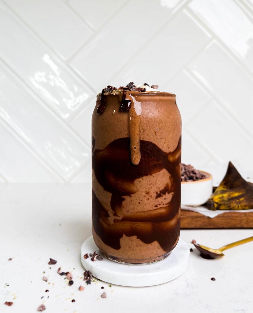a glass of dark chocolate smoothie with chocolate swirls