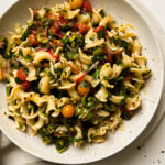 cherry tomato pasta salad in a speckled bowl