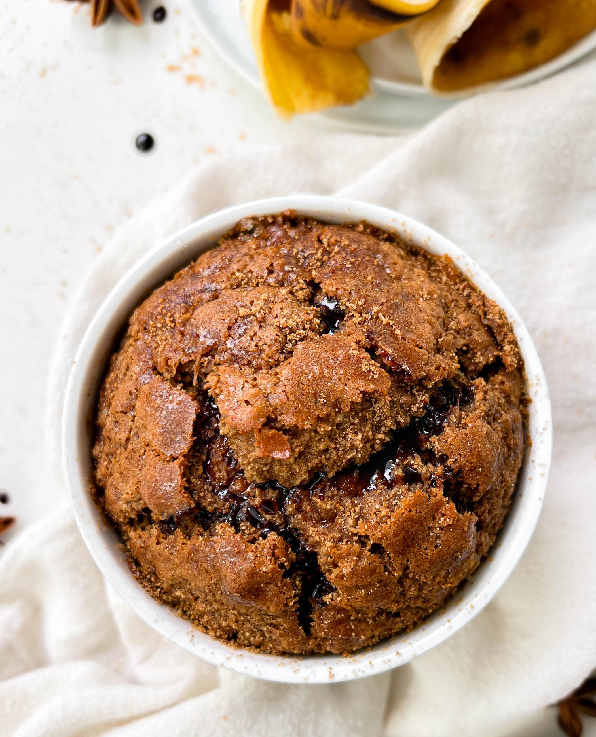 fluffy gingerbread baked oats in a ramekin next to banana peels and coconut sugar