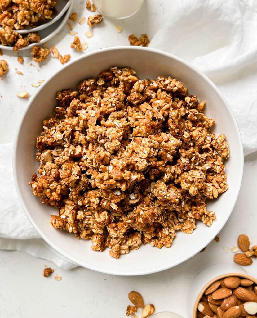 homemade cereal in a bowl next to a bottle of milk