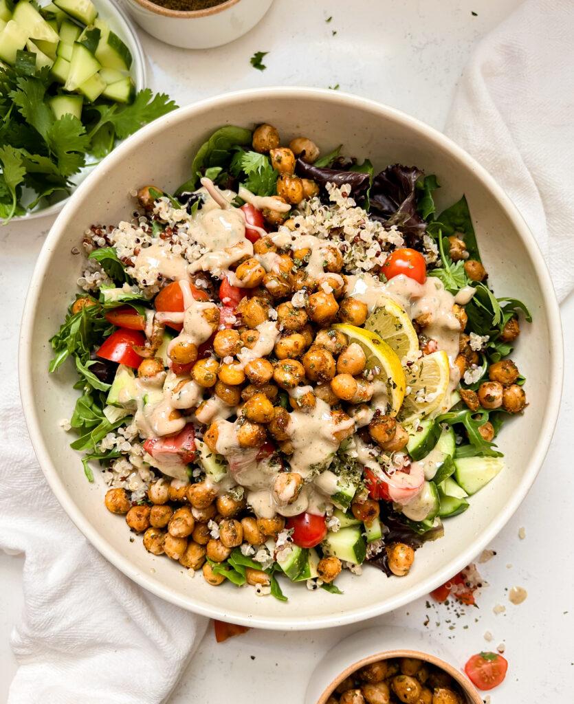 roasted chickpea salad bowl in a beige bowl next to a white linen cloth