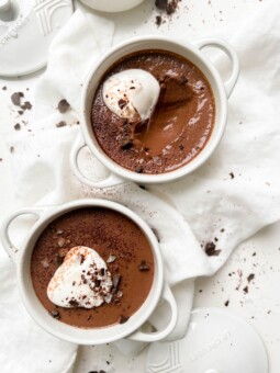 vegan chocolate pudding in a white ramekin with coconut yogurt and chocolate on top