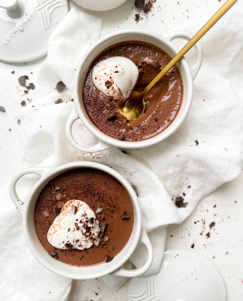 vegan chocolate pudding in a white ramekin with coconut yogurt and chocolate on top