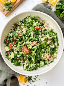 tabbouleh salad in a white bowl on a green linen cloth