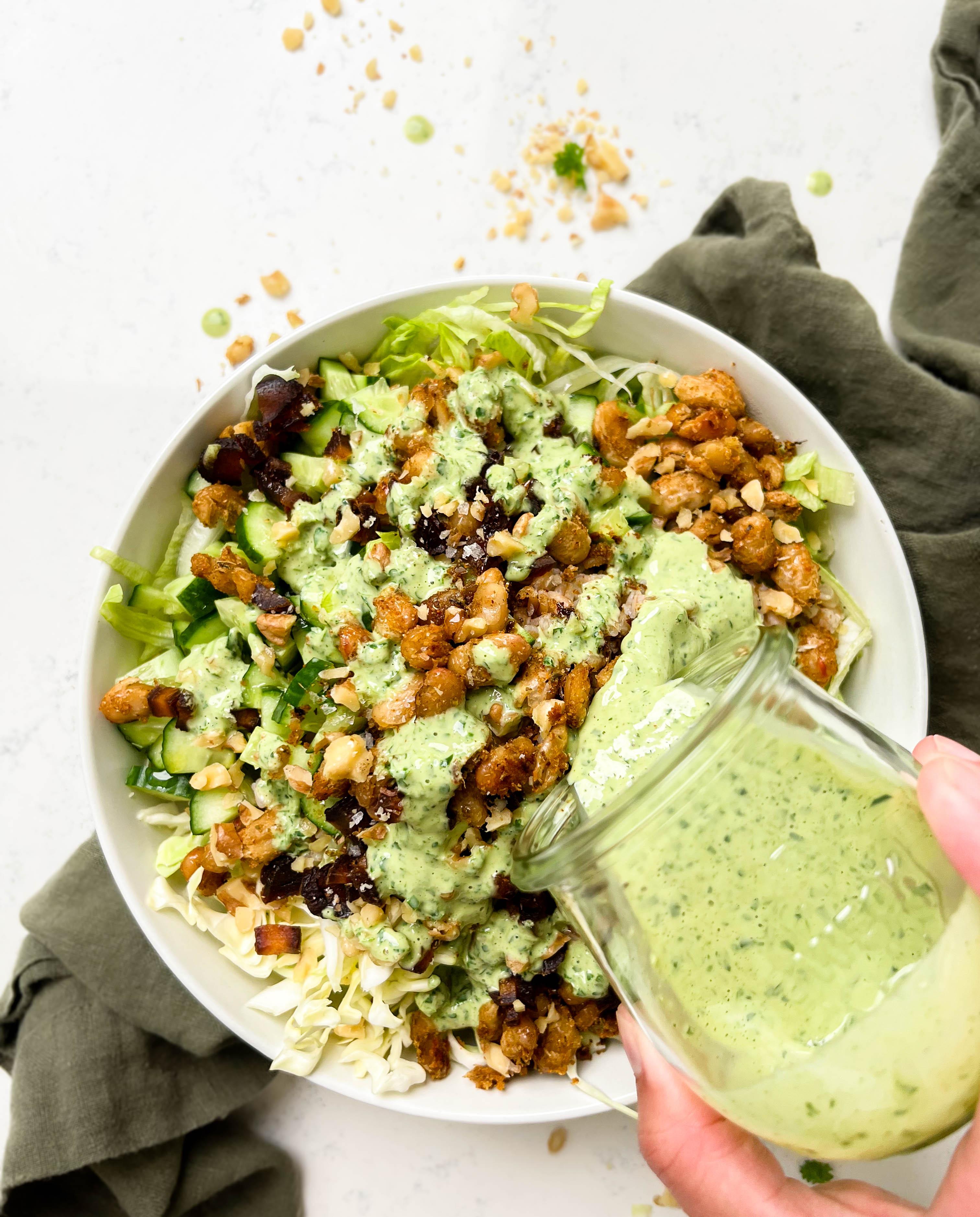 crunchy green cabbage salad with beans and farro next to parsley tahini dressing