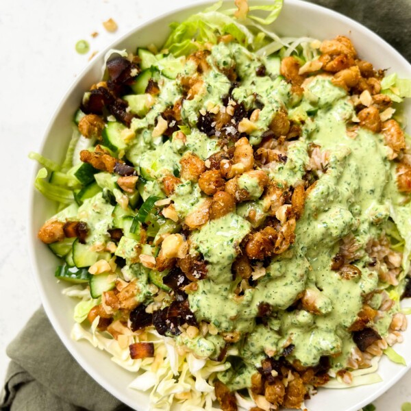 crunchy green cabbage salad with beans and farro next to parsley tahini dressing