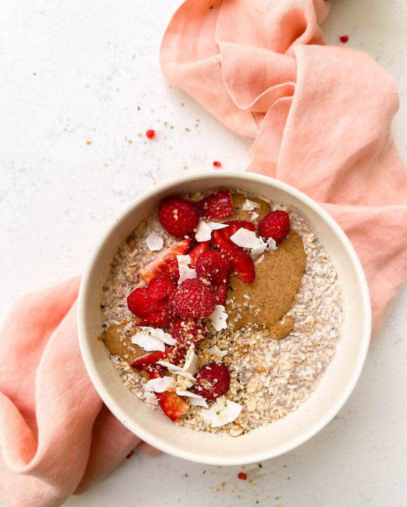 bowl of vanilla overnights oats with berries and coconut flakes on top