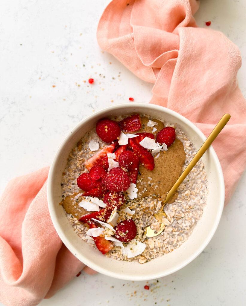 bowl of vanilla overnights oats with berries and coconut flakes on top