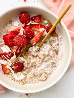 bowl of vanilla overnights oats with cashew milk, berries and coconut flakes on top