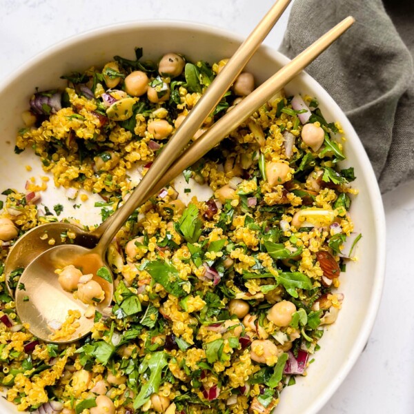 bowl of golden moroccan quinoa salad on a green linen cloth