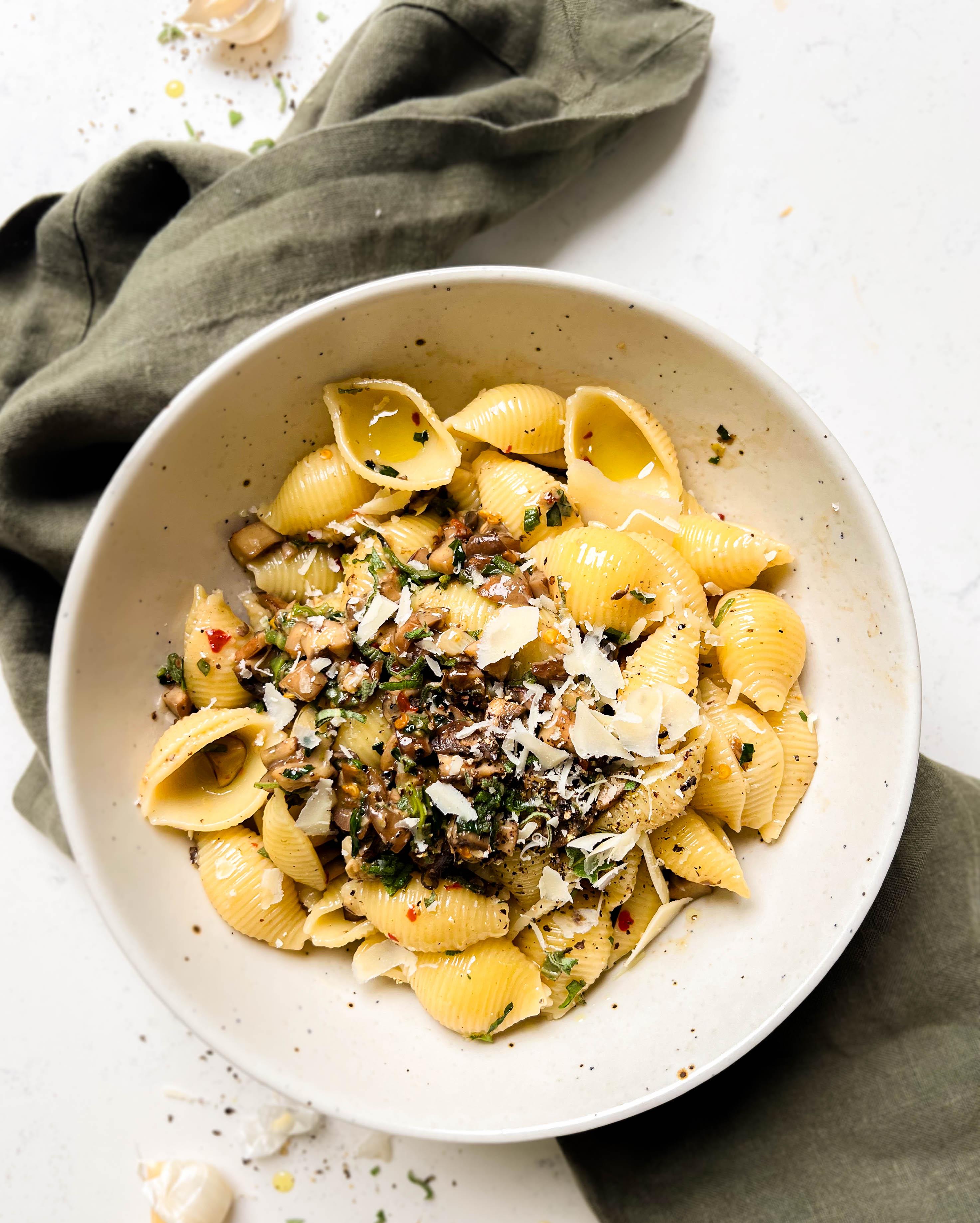 brown butter sage pasta in a beige bowl on a green linen cloth