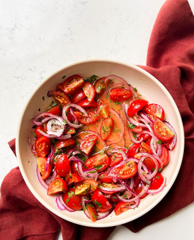 bowl of tomato salad on a red cloth