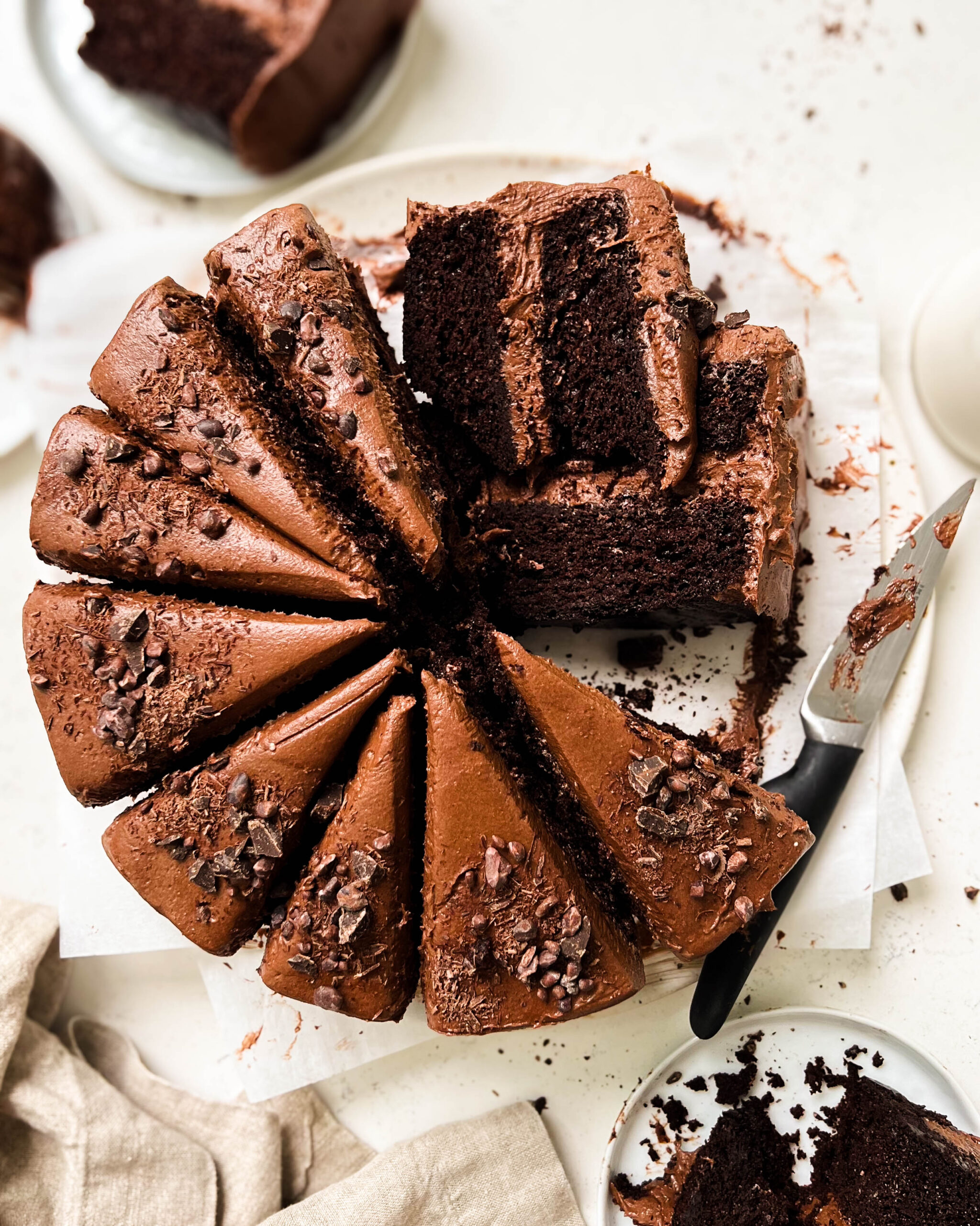 vegan chocolate cake cut into slices on a white plate