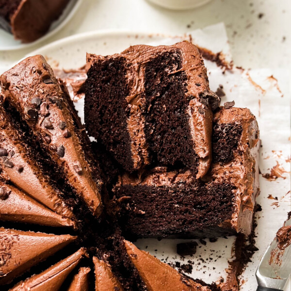 vegan chocolate cake cut into slices on a white plate