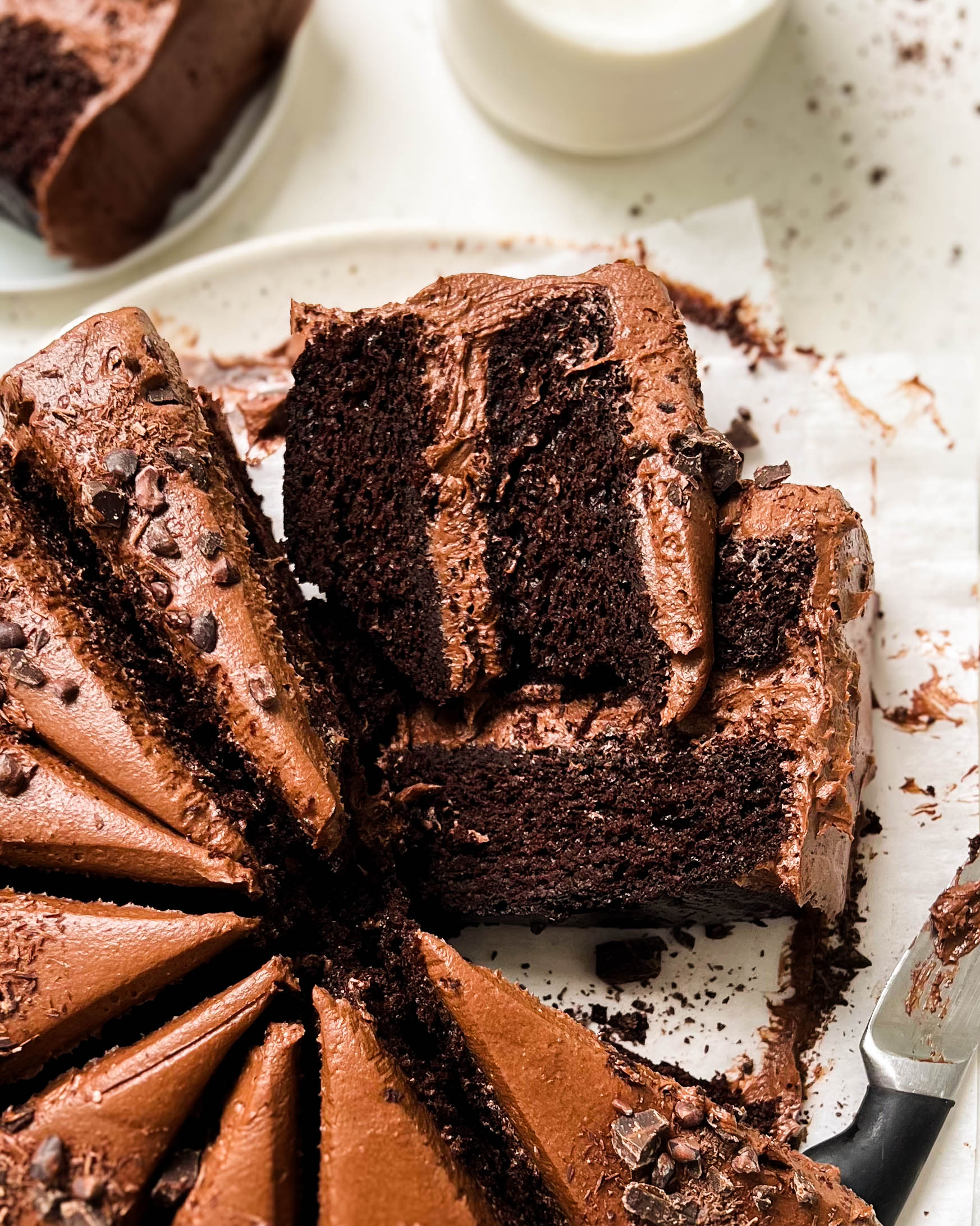 vegan chocolate cake cut into slices on a white plate