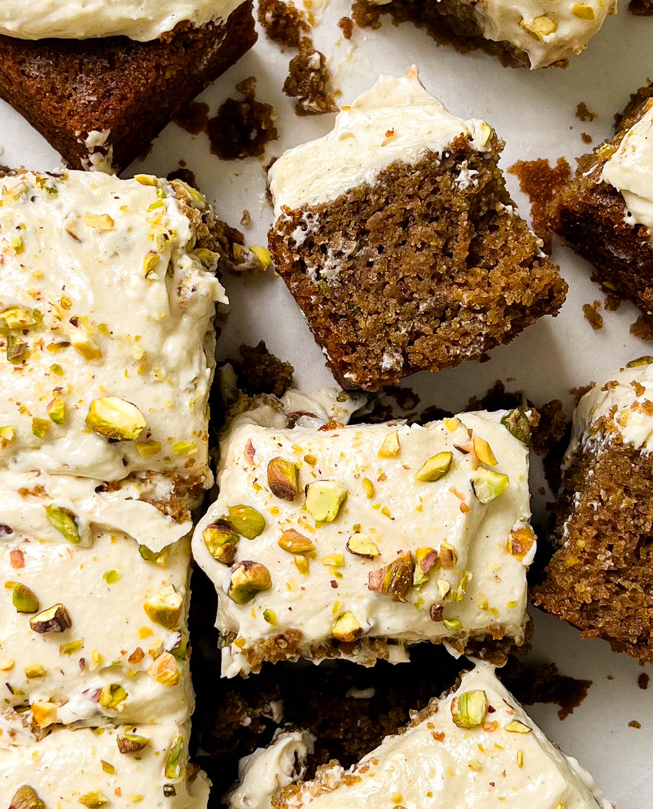 sliced cardamom pistachio cake on parchment paper