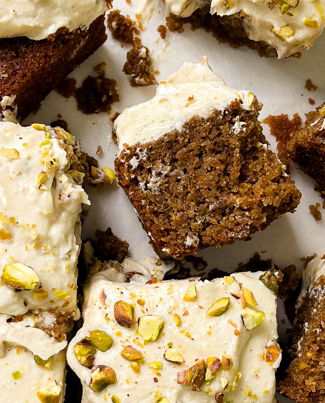 sliced cardamom pistachio cake on parchment paper