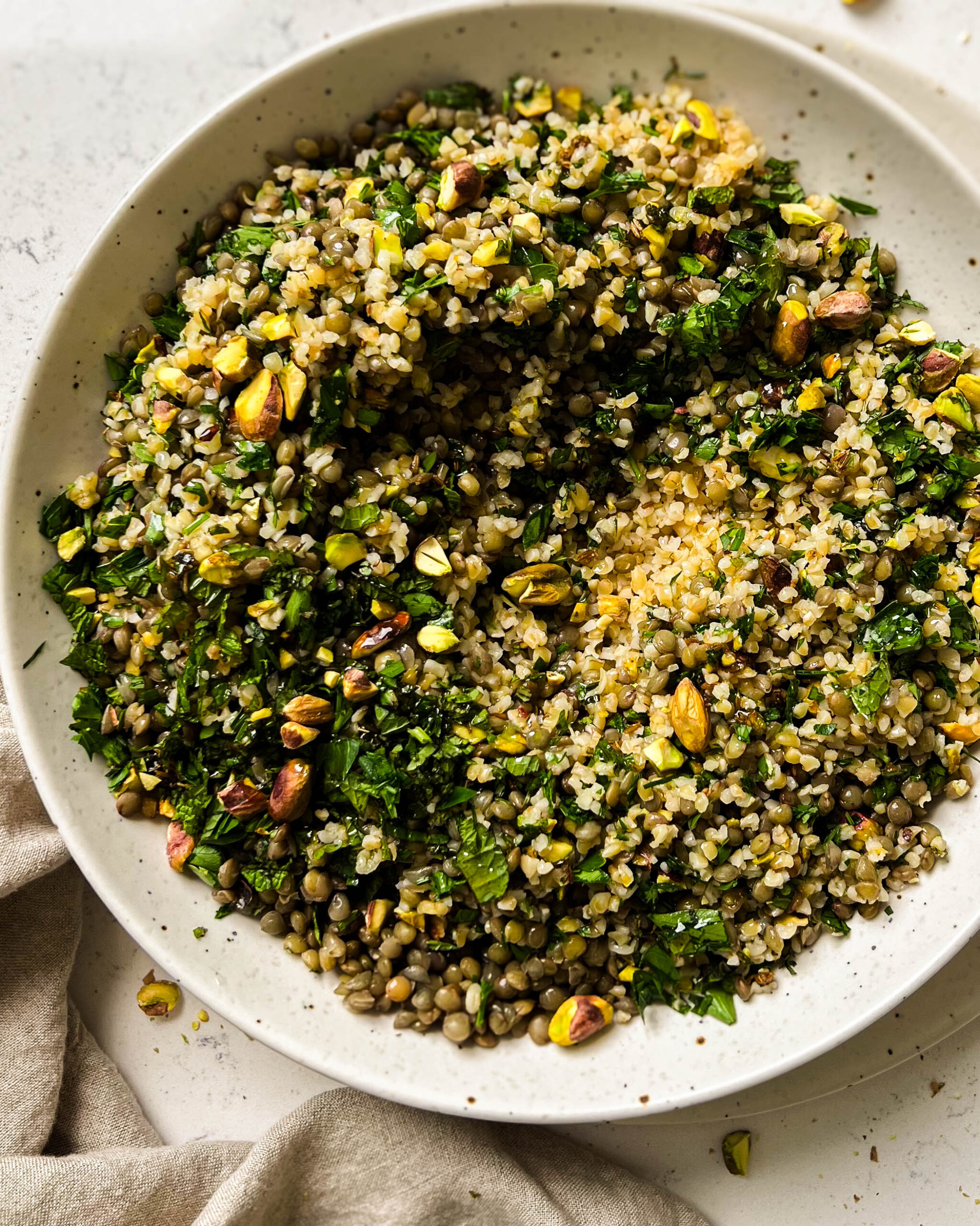 bulgur salad in a bowl next to a linen cloth