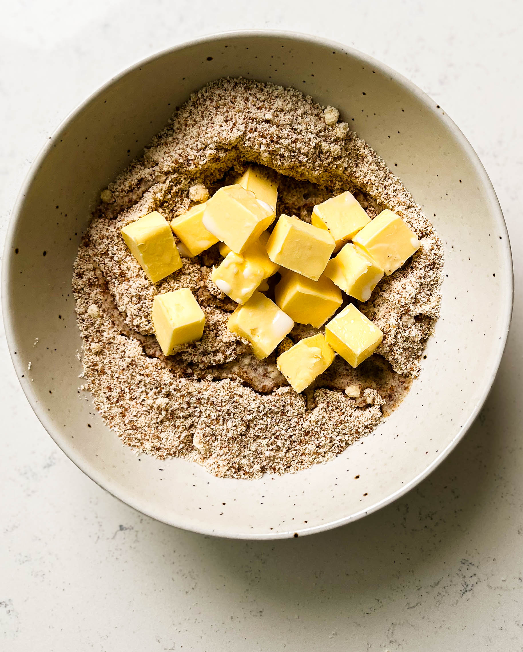 bowl of almond flour and coconut sugar with butter cubes