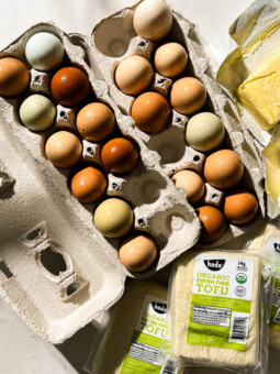 fresh eggs, tofu, and butter on a white counter
