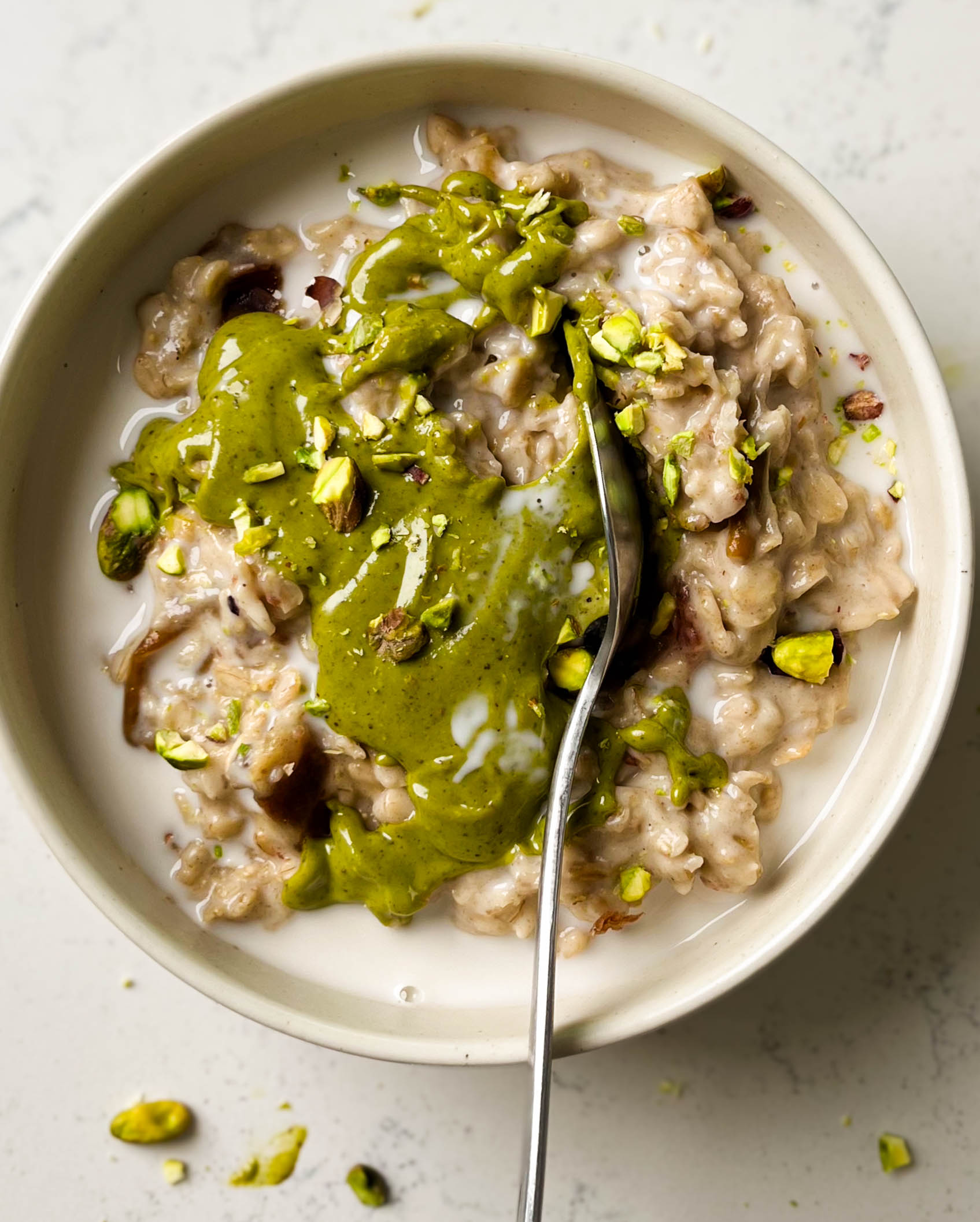 bowl of cardamom pistachio oatmeal with a spoon