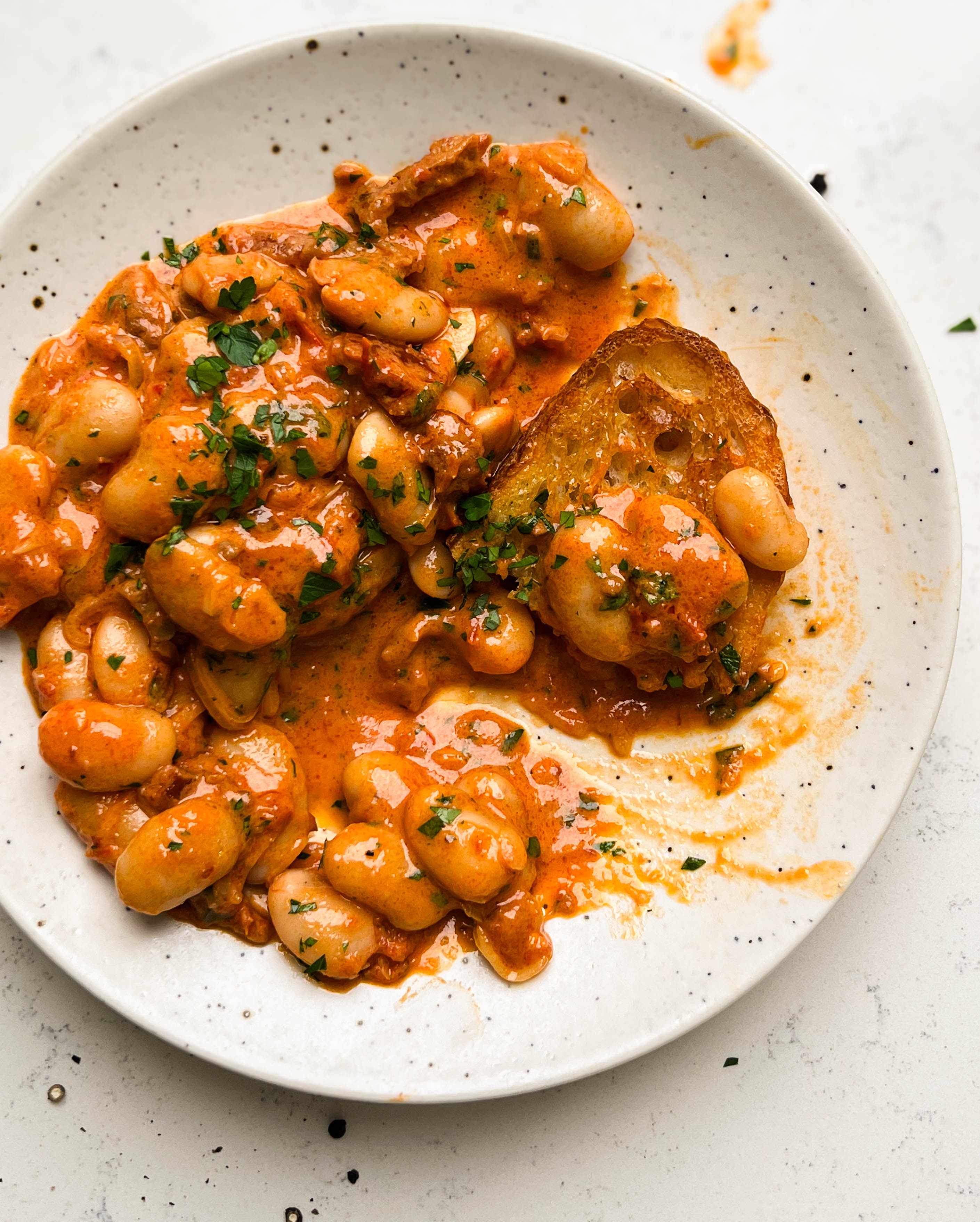 spicy tomato butter beans on a plate with toast