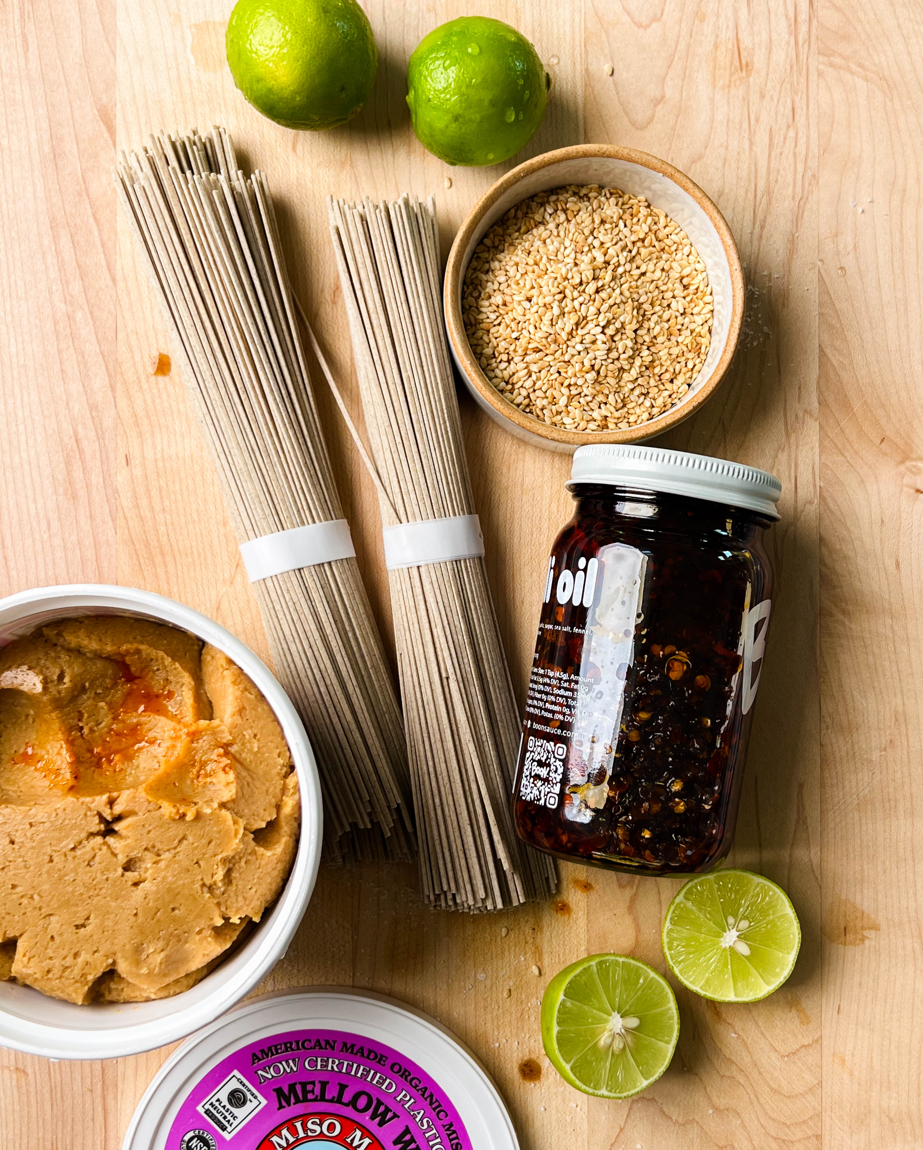 noodles, sesame seeds, miso, and chili crisp on cutting board